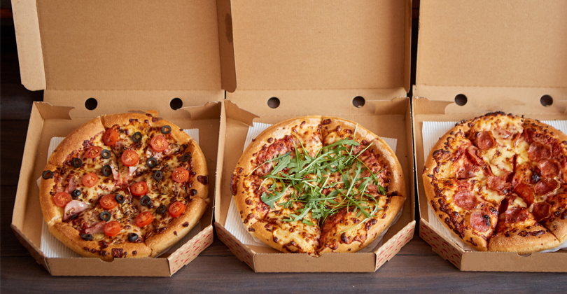 3 caixas com pizza dentro, quentinhas, prontas para serem entregues via delivery.